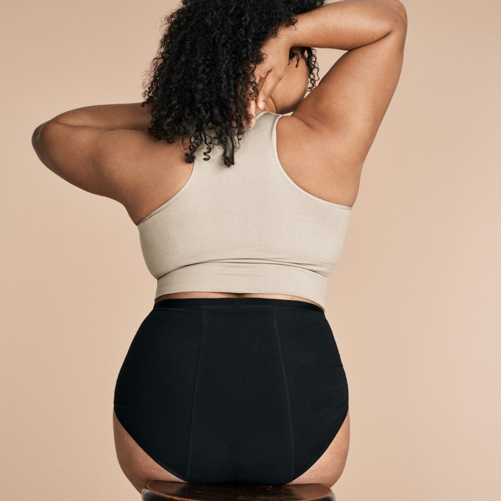 Vrouw met zwart menstruatieondergoed van ImseVimse van de achterkant