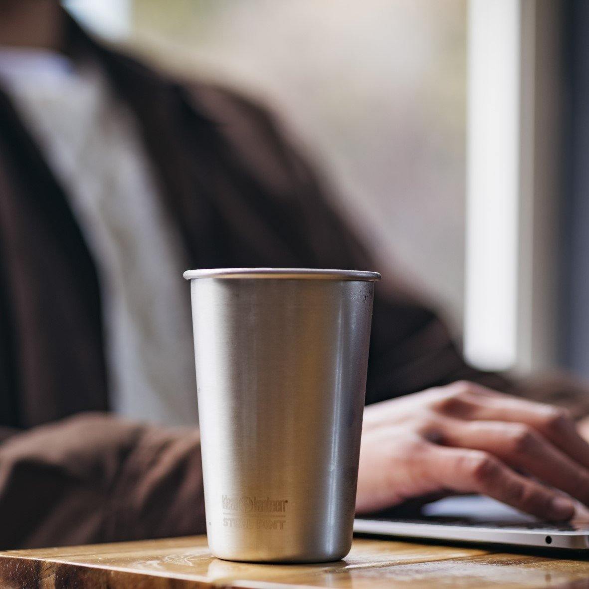 Een foto van een Klean Kanteen RVS Beker achter een laptop